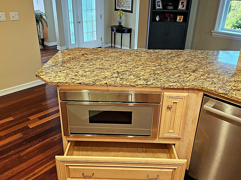 Custom maple island cabinetry with a built-in warming drawer